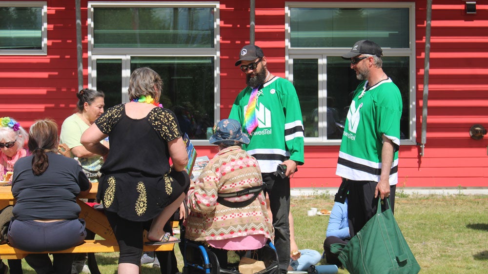 Curtis Wright and another Northwestel teammate visit Mayo for the community’s annual Pride Parade