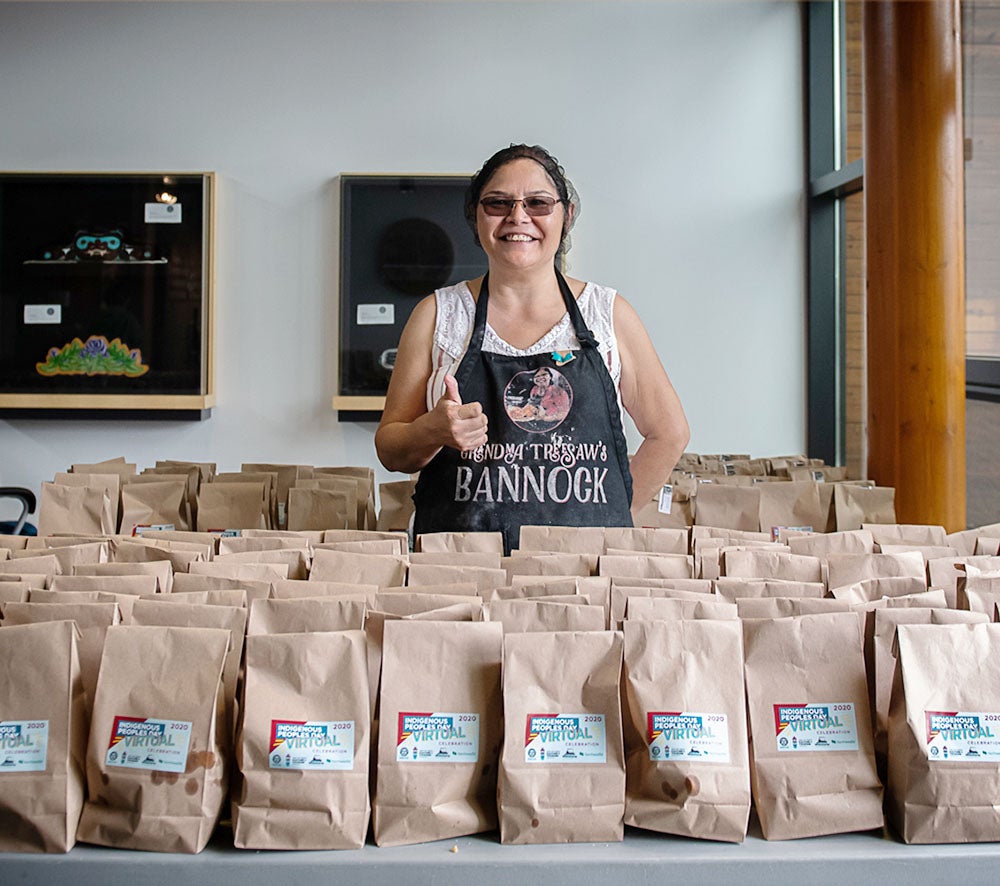 Grandma Treesaw Portrait in front of bags filled with bannock