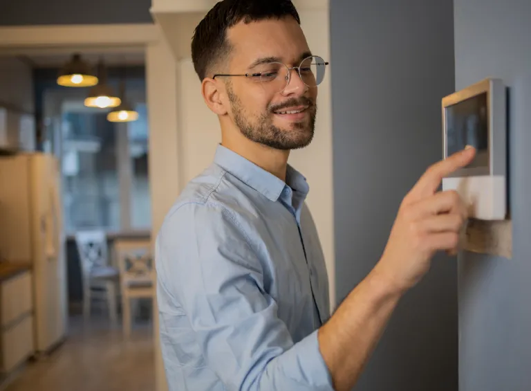 Person adjusting temperature using a smart thermostat