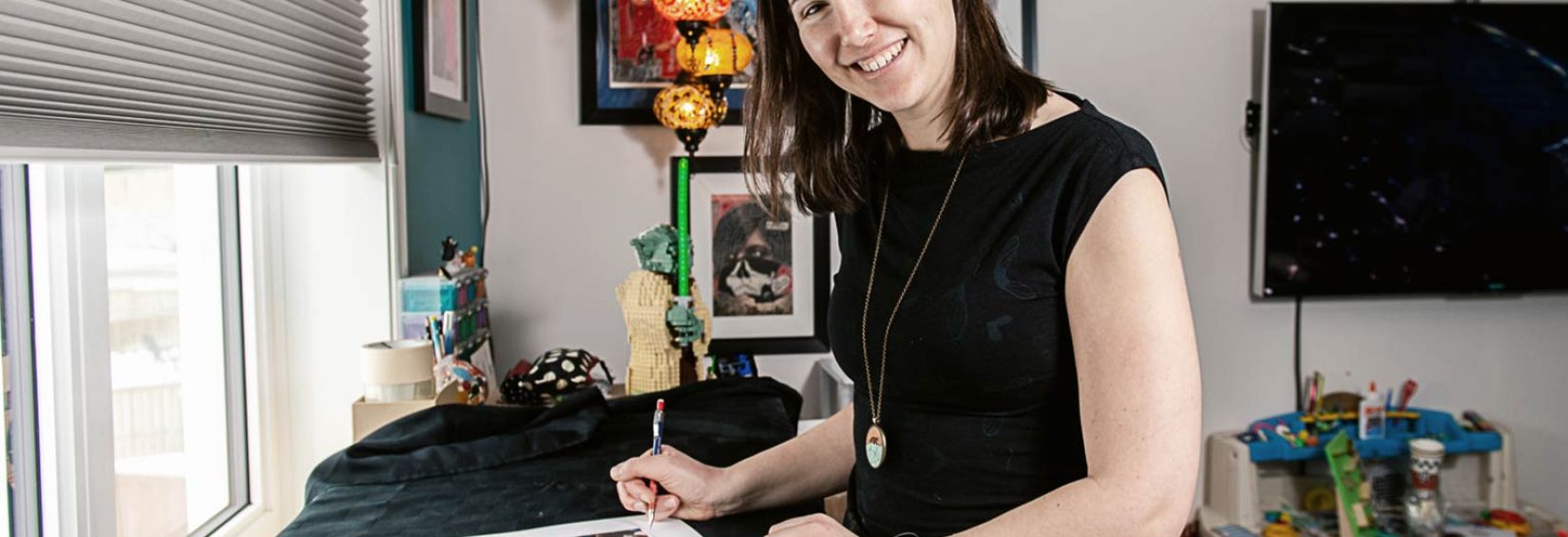 Yukon directory art winner Woman at desk with art piece