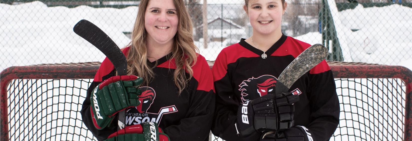 Megan and her daughter Emery standing in front of a hockey net