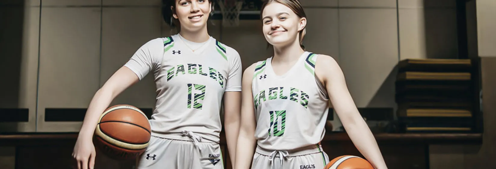 Give a girl an opportunity to thrive in basketball, and there’s no limit to what they can accomplish both on and off the court. Lilly and Grace stand on the court, basketball in their hands, smiling brightly.