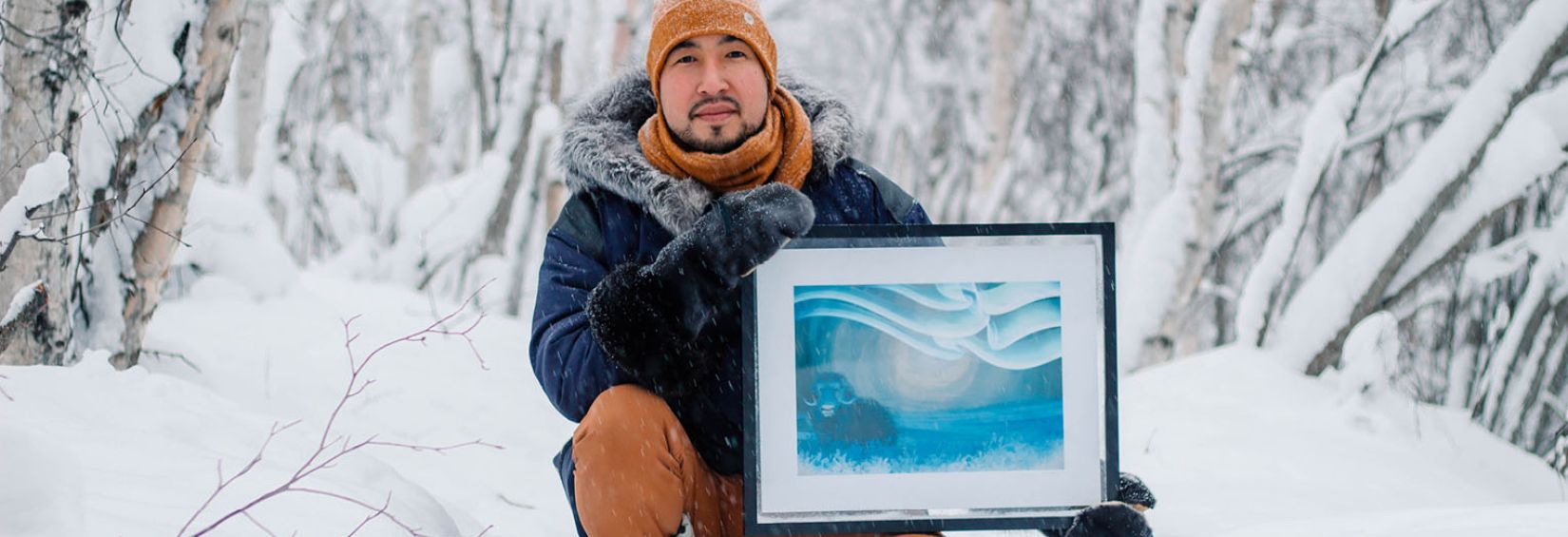 Brian Kowikchuk and a print of his digital artwork, Uumingmak (Muskox).