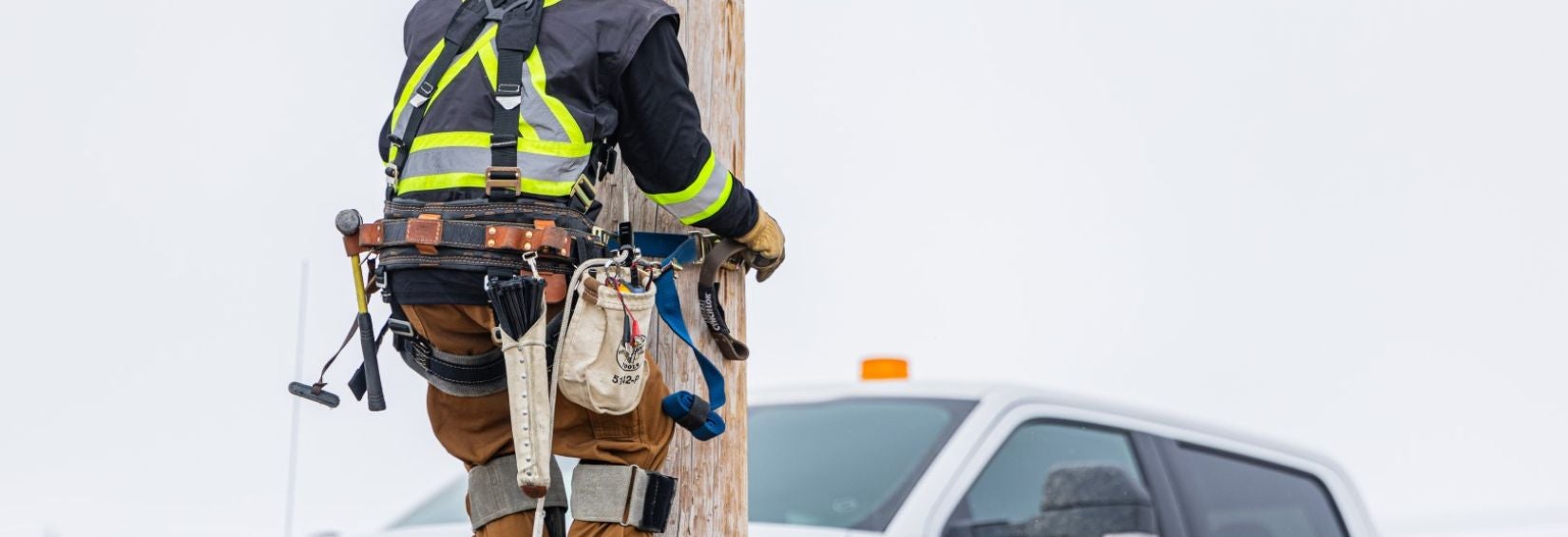 Northwestel technican climbing roadside pole