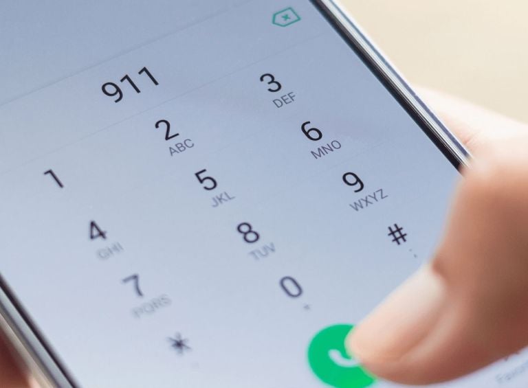 Person dialing 911 on their mobile